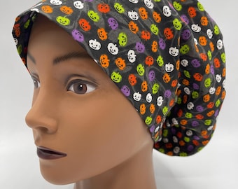 May include: A black scrub hat with a repeating pattern of orange, green, and white jack-o'-lanterns.