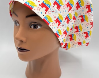 May include: White scrub hat with a repeating pattern of red, white, and blue elephants with yellow hair. The elephants are wearing a blue and white hat with a red star.