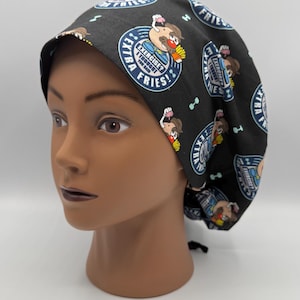 May include: A black scrub cap featuring a repeating pattern of cartoon potato characters holding french fries. The circular graphic includes the text "EXERCISE? I THOUGHT YOU SAID EXTRA FRIES!" in white and blue lettering, interspersed with small dumbbells.