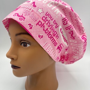 May include: Pink surgical scrub hat with a white background and pink text. The text includes the words "you try driving in platforms" and "I totally".