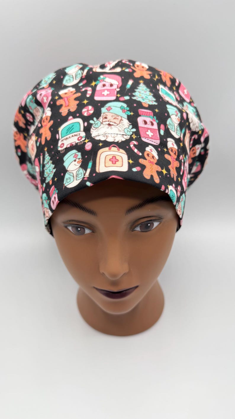 May include: A black scrub cap with a colorful Christmas-themed pattern. The pattern includes gingerbread men, Santa Claus, Christmas trees, and medical symbols. The cap is designed to be worn in a medical setting.