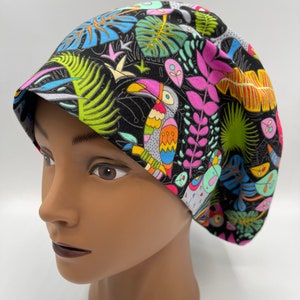 May include: A black scrub hat with a colorful tropical print featuring toucans, leaves, and flowers.