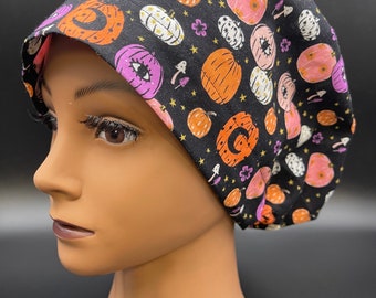 May include: Black scrub hat with a colorful pumpkin and star pattern.
