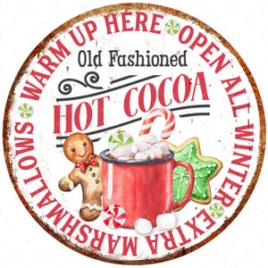May include: A round, rusty metal sign with the text "Warm Up Here Open All Winter Extra Marshmallows Old Fashioned Hot Cocoa". The sign features a red mug of hot cocoa with marshmallows, a gingerbread man, a candy cane, and a green and white cookie.