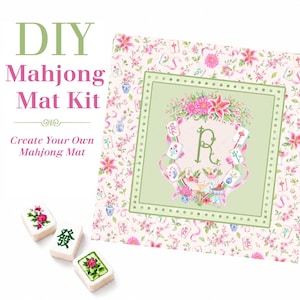 May include: A DIY Mahjong Mat Kit featuring a square fabric panel with a pink floral pattern, a central green square with a letter R, and three white Mahjong tiles with green and pink floral designs and Chinese characters on a white background.