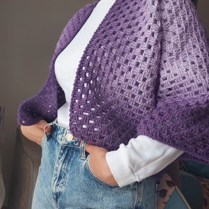 Könnte beinhalten: Eine violette Ombre-Häkeljacke mit lockerer Passform und einem weiten, offenen Ausschnitt.