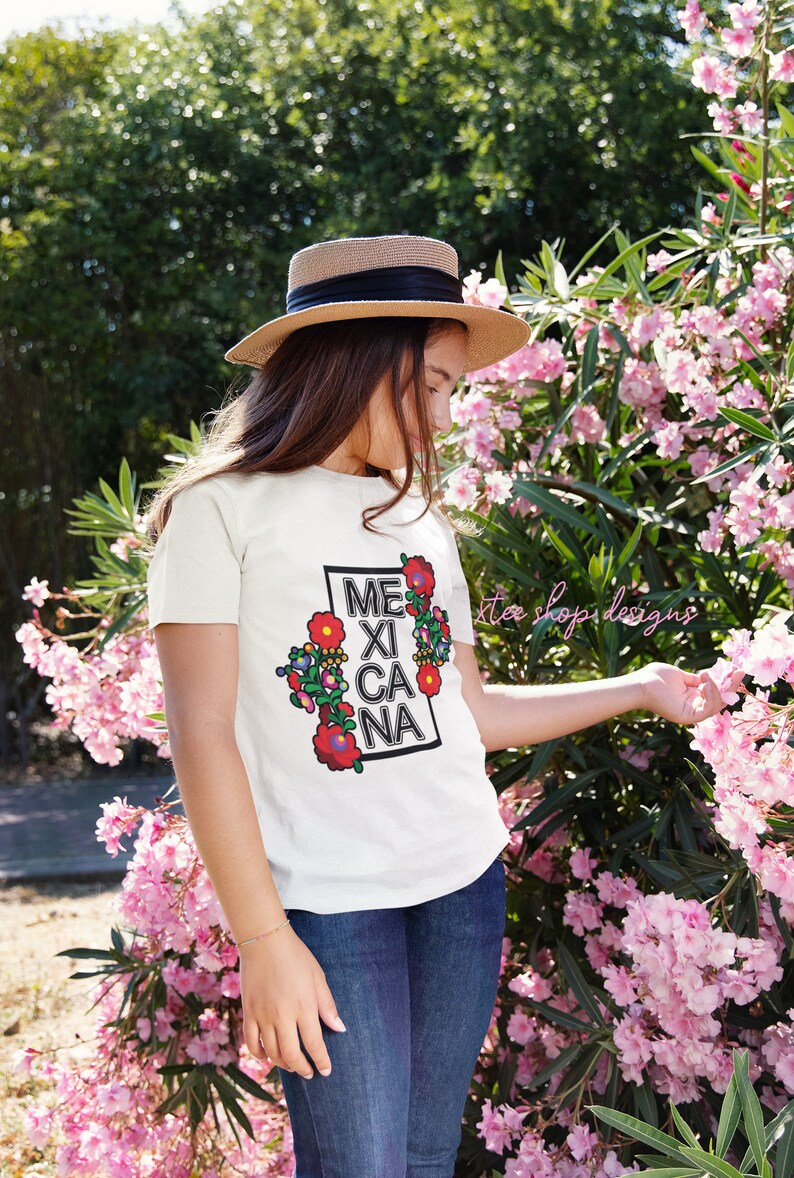 May include: A white t-shirt with a colorful floral design and the text "MEXICANA" in a black box.