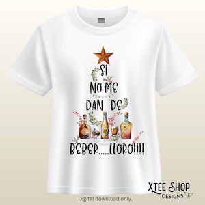 May include: A white short-sleeved t-shirt featuring a graphic of a Christmas tree formed by text and alcohol bottles. The text reads SI NO ME DAN DE BEBER.....LLORO!!!!. The design includes a brown star, holly, and various liquor bottles.