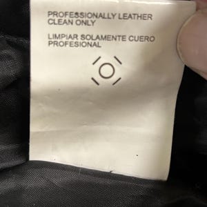 Puede incluir: Una etiqueta de cuidado blanca con texto negro que dice "PROFESIONALMENTE CUERO LIMPIAR S&Oacute;LO" y "LIMPIAR SOLAMENTE CUERO PROFESIONAL". La etiqueta tambi&eacute;n presenta un s&iacute;mbolo de cuidado.