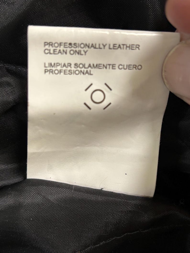 Puede incluir: Una etiqueta de cuidado blanca con texto negro que dice "PROFESIONALMENTE CUERO LIMPIAR S&Oacute;LO" y "LIMPIAR SOLAMENTE CUERO PROFESIONAL". La etiqueta tambi&eacute;n presenta un s&iacute;mbolo de cuidado.