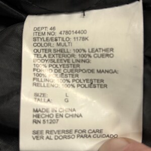 Puede incluir: Primer plano de una etiqueta blanca con texto negro. La etiqueta enumera el departamento, el n&uacute;mero de art&iacute;culo, el estilo y el color como multi. Tambi&eacute;n enumera los materiales: 100% cuero, forro y relleno de poli&eacute;ster. Talla L.