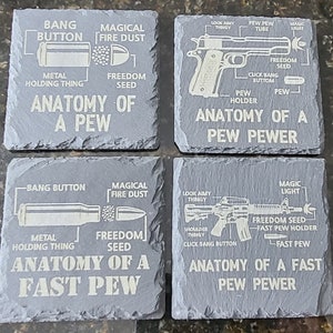May include: Four black slate coasters with white text and illustrations depicting the anatomy of a gun. The coasters feature the text "Anatomy of a Pew", "Anatomy of a Pew Pewer", "Anatomy of a Fast Pew", and "Anatomy of a Fast Pew Pewer".