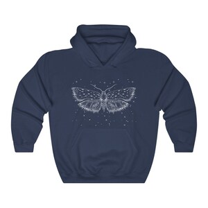 May include: A navy blue hoodie with a white outline of a moth with wings spread wide. The moth is surrounded by small white dots, resembling stars.