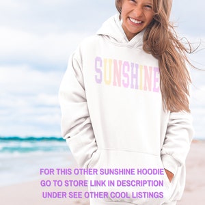 Peut inclure: Sweat-shirt blanc avec le mot "SUNSHINE" en couleurs arc-en-ciel sur le devant. Le texte "FOR THIS OTHER SUNSHINE HOODIE GO TO STORE LINK IN DESCRIPTION UNDER SEE OTHER COOL LISTINGS" est imprim&eacute; sous le graphique.