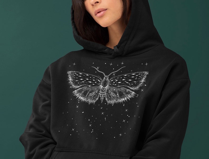 May include: Black hoodie with a white moth graphic on the front. The moth is surrounded by white stars.
