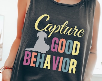 May include: A black tank top with the text "Capture Good Behavior" in colorful letters. A gray silhouette of a dog is next to the word "Capture".