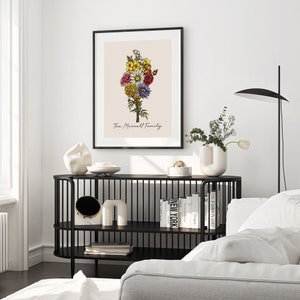 May include: A black framed print featuring a bouquet of colourful flowers on a cream background. The text "The Marrell Family" is printed below the flowers.
