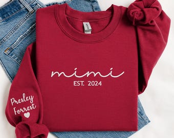 May include: Red sweatshirt with the text "mimi est. 2024" on the front and "Presley Forrest" with a heart on the left sleeve.