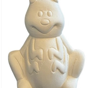 May include: A ceramic frog figurine in a sitting position, painted in a solid off-white color. The frog has a smiling face, large eyes, and a rounded body. The figurine is designed with a cartoonish aesthetic.