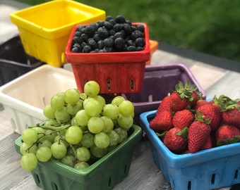 Könnte beinhalten: Ein Set aus sechs Keramik-Obstkörben in verschiedenen Farben, darunter Gelb, Rot, Weiß, Grün, Blau und Lila. Die Körbe sind mit Blaubeeren, Trauben und Erdbeeren gefüllt.