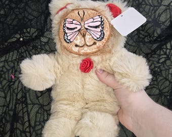 Oso de peluche con cara de mariposa y cara de arcilla