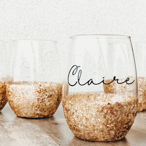 Chunky gold glitter wine glass with the Claire font. Black vinyl.
You can order the wine glass in a number of glitter colors and in your choice of font. Each glass is made to order.