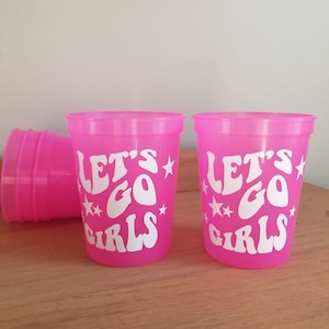 16 oz Stadium plastic cup that changes from Pink to Purple when ice cold drinks are added. White vinyl that says, "Let's Go Girls."