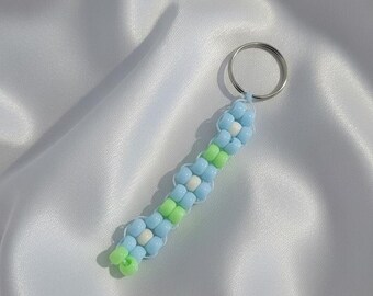 Llavero artesanal hecho con cuentas de pony azul brillante en forma de flor.