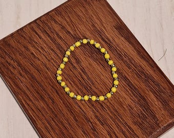 Pulsera elástica hecha a mano con cuentas amarillas y doradas