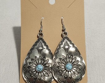 Pendientes colgantes de plata hechos a mano con estampado floral y una cuenta azul de acento.