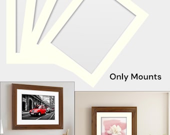 May include: Cream-colored picture frame mats with rectangular openings, stacked against a light gray background. The image also shows framed artwork, including a red car in a city scene and a floral print, demonstrating how the mats are used.