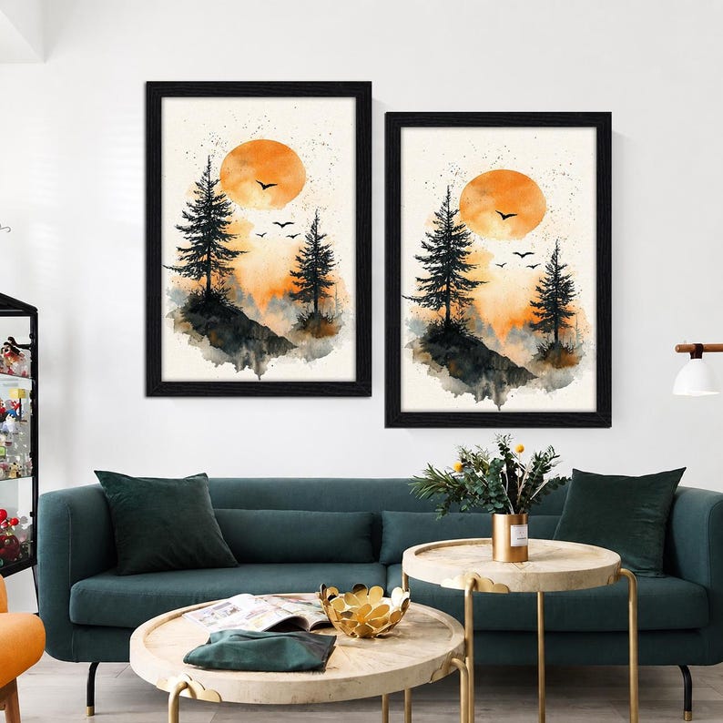 Peut inclure: Deux cadres muraux repr&eacute;sentant des paysages &agrave; l'aquarelle avec des silhouettes noires de pins et d'oiseaux devant un grand soleil orange. L'&oelig;uvre utilise une palette de tons orange, noir et cr&egrave;me, pr&eacute;sent&eacute;e dans des cadres noirs assortis.