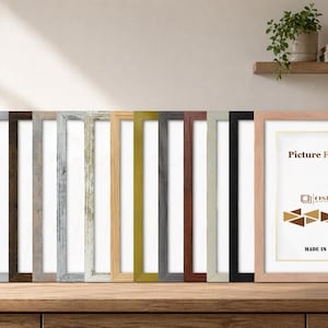 May include: A collection of rectangular picture frames in various finishes including white, wood grain, metallic, grey, black, and natural light wood. The frames are arranged in a row, with one frame in the foreground displaying the text Picture Frame, OSUK, and MADE IN UK.