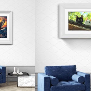 May include: Two framed wall art prints displayed in a room. The left vertical frame shows a bald eagle flying over mountains at sunset. The right horizontal frame depicts a black cat and a white cat peering over a wooden roof amidst green foliage.