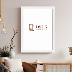 May include: A rectangular white picture frame hanging on a wall, featuring a central logo with two overlapping square outlines and the text "OSUK ONLINE SUPPLIES UK" in a metallic bronze colour printed on the white background inside the frame.