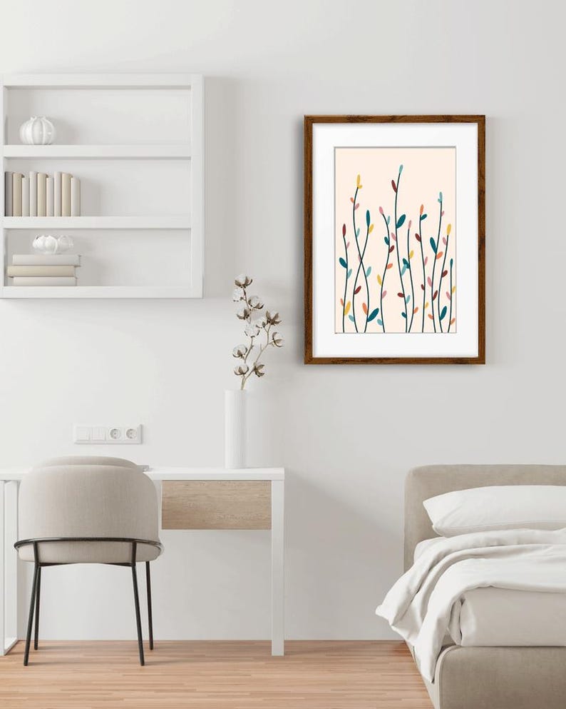 May include: A framed wall art print featuring a series of thin, vertical stems with small, colorful leaves in shades of teal, yellow, pink, and dark red against a light cream background, enclosed in a dark brown wooden frame.