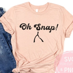 May include: A pink t-shirt with the text "Oh Snap!" in black with a wishbone graphic below.