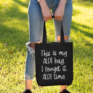 Op de afbeelding: Een zwarte tote bag met de tekst "This is my ALDI bag. I forget it ALDI time." in wit gedrukt.