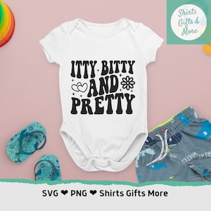 May include: White baby onesie with black text that reads "itty bitty and pretty" with a heart and flower graphic.