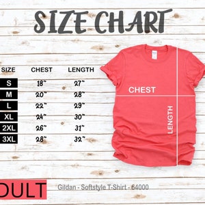 Puede incluir: Tabla de tallas para camisetas de adulto, que muestra las medidas de pecho y largo en pulgadas para las tallas S, M, L, XL, 2XL y 3XL. La tabla est&aacute; sobre un fondo de madera. Gildan - Softstyle T-Shirt - 64000