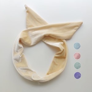 May include: A cream-colored velvet headband tied in a knot. The headband is soft and stretchy, and can be worn in a variety of ways.