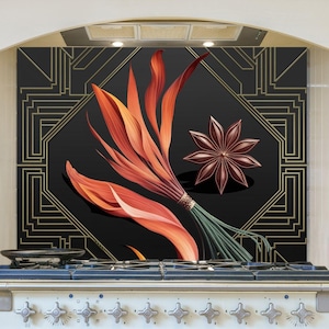 May include: A kitchen backsplash featuring a black background with a gold geometric design. A bundle of orange and red leaves and a star anise are in the center. The backsplash is above a white stove.