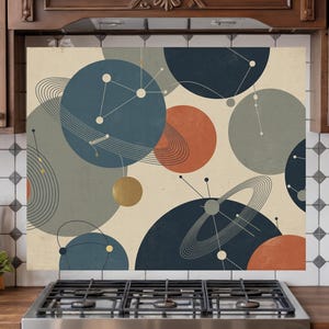 May include: A decorative kitchen backsplash featuring a mid-century modern design with overlapping circles in shades of blue, orange, gray, and gold against a cream background. The design includes lines and dots, creating a celestial or planetary theme.