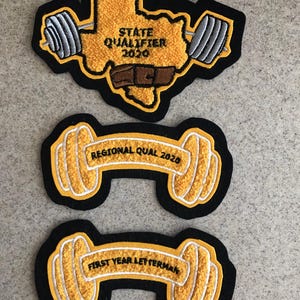 May include: Three embroidered patches with black borders. The top patch features a yellow Texas outline with "STATE QUALIFIER 2020" and a barbell design. The other two patches have a dumbbell shape with text: "REGIONAL QUAL 2020" and "FIRST YEAR LETTERMAN".