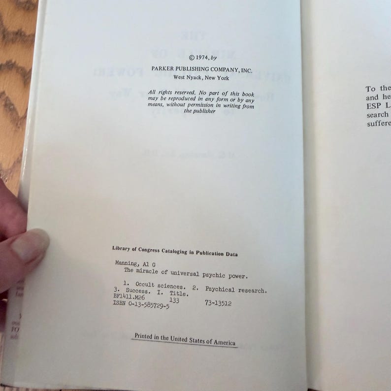 May include: Open book pages with text from "The miracle of universal psychic power" by Al G. Manning. The text includes copyright information, Library of Congress Cataloging data, and ISBN. Printed in the United States of America.