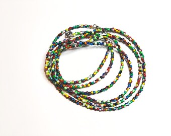 May include: Multicolored beaded necklace with a silver clasp. The necklace is made of small, round beads in various shades of red, green, blue, yellow, and white.