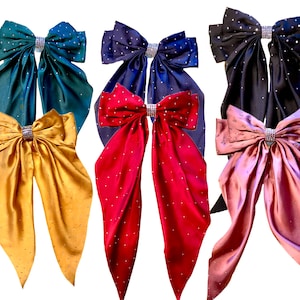 May include: Six satin ribbon bows with rhinestone embellishments in various colors, including teal, navy, burgundy, gold, and mauve.