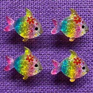 May include: Four rainbow glitter fish with a flower on top. The fish are made of plastic and have a shiny finish.