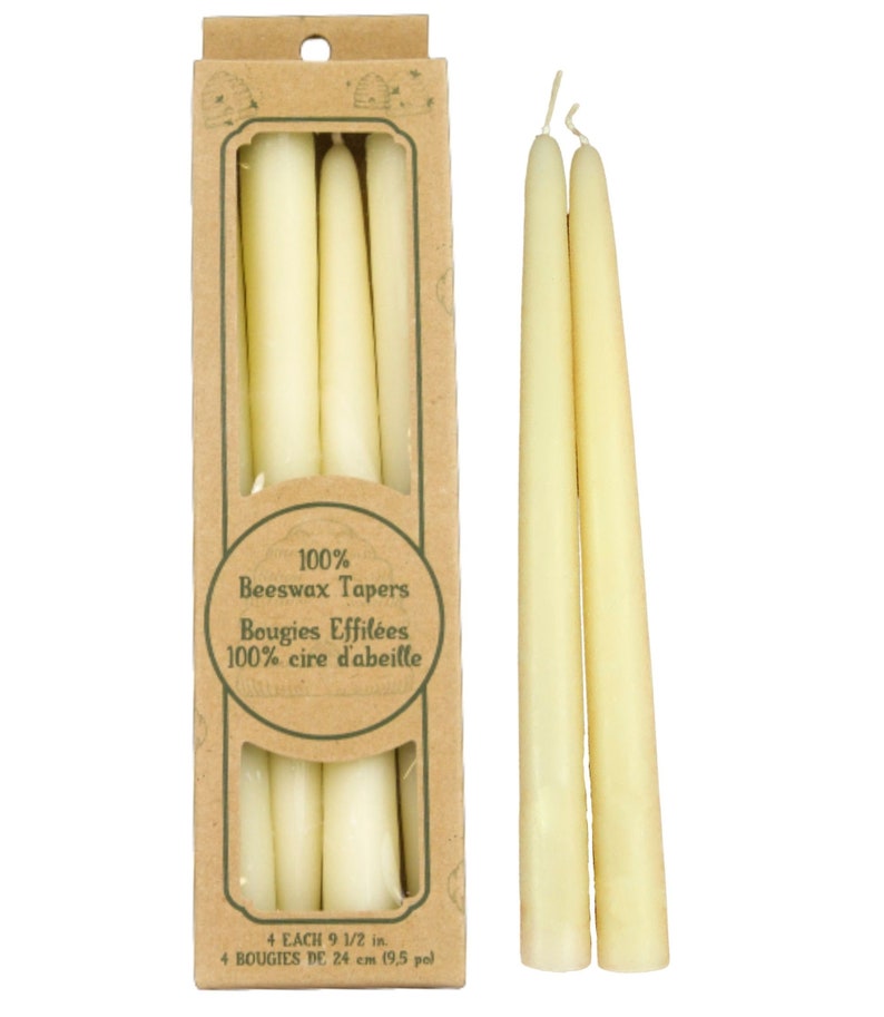 Op de afbeelding: Een doos met vier 100% bijenwaskaarsen, elk 24 cm lang. De doos is gemaakt van bruin karton en heeft een groen label met de tekst "100% Beeswax Tapers" en "Bougies Effil&eacute;es 100% cire d'abeille".