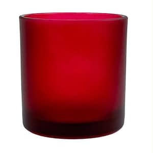 Puede incluir: Un portavelas cilíndrico de vidrio con un color rojo intenso y vibrante y un acabado mate esmerilado. El recipiente presenta una base de vidrio transparente y gruesa, junto con una parte superior ancha y abierta, con una forma sencilla.